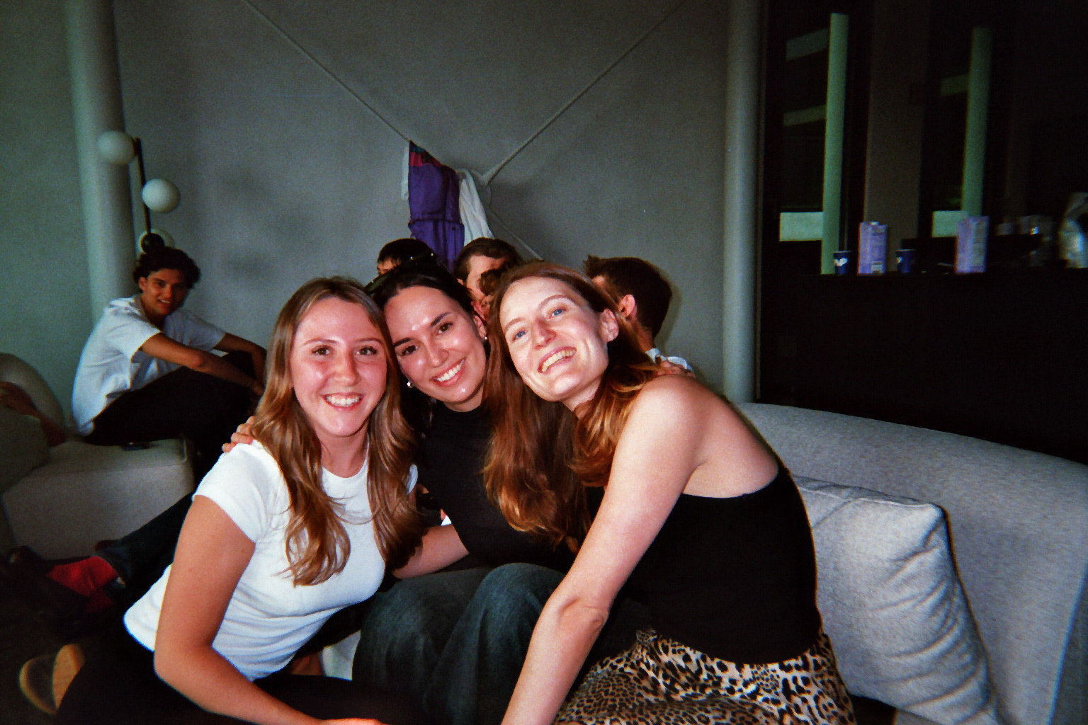 Three colleagues smiling on the office sofa