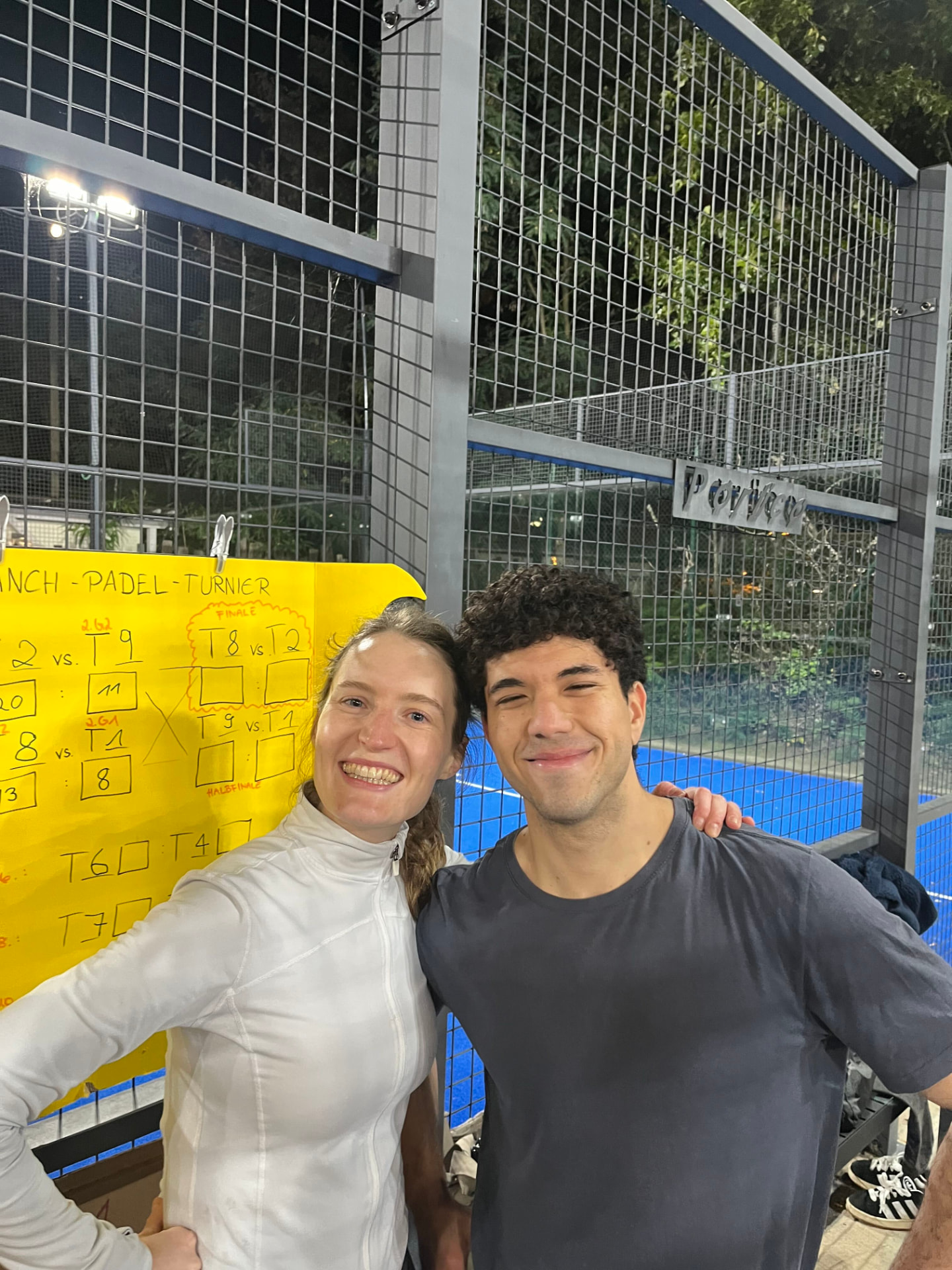 Two colleagues smiling at the LANCH padel tournament