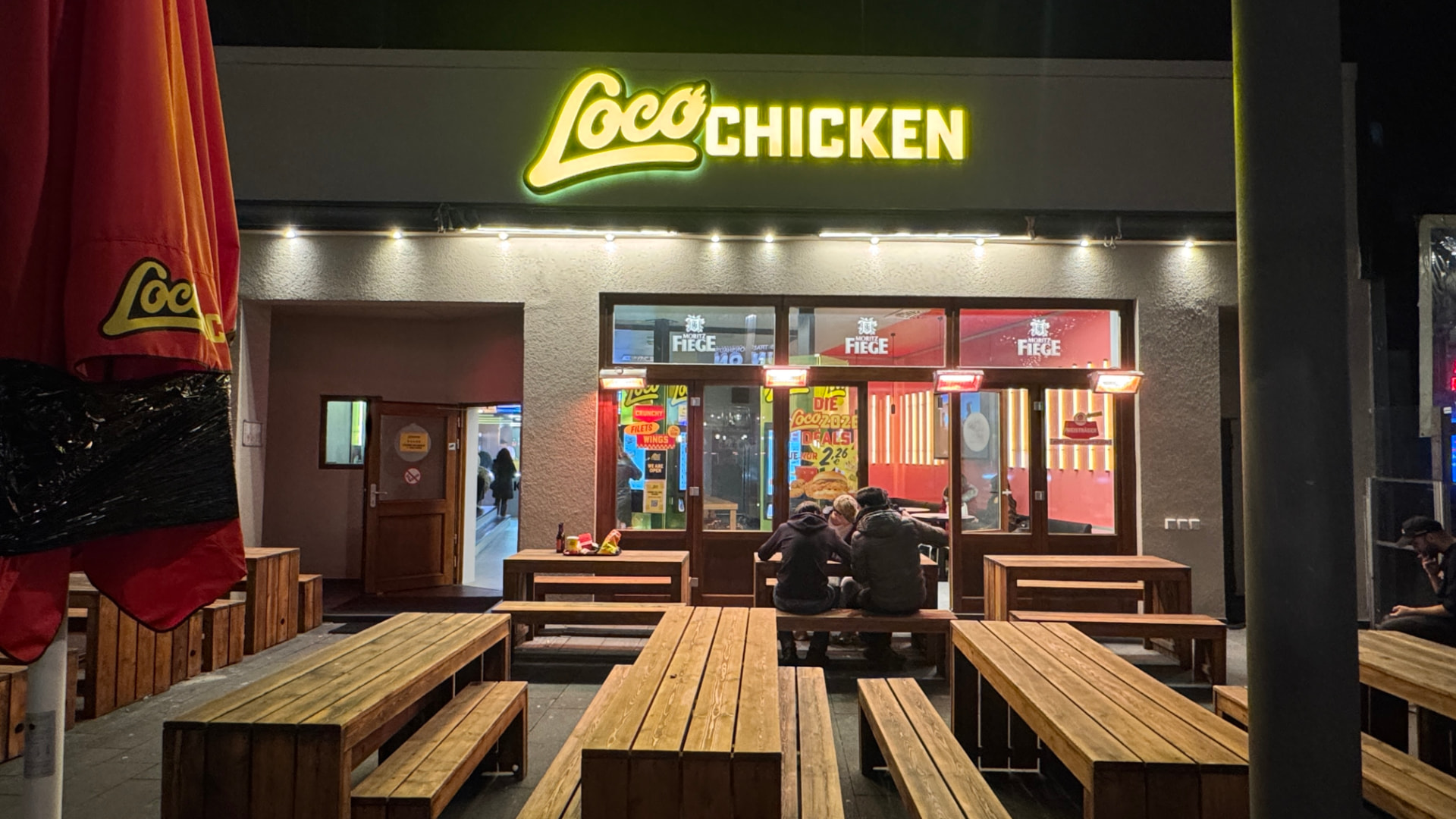 Loco Chicken Store in Bochum bei Nacht mit Außenbereich
